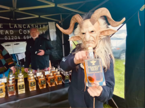 A Krampus figure holding a bottle of Krampus Spiced Mead at our stall